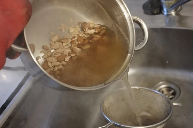 Using a strainer to filter the acorn pieces